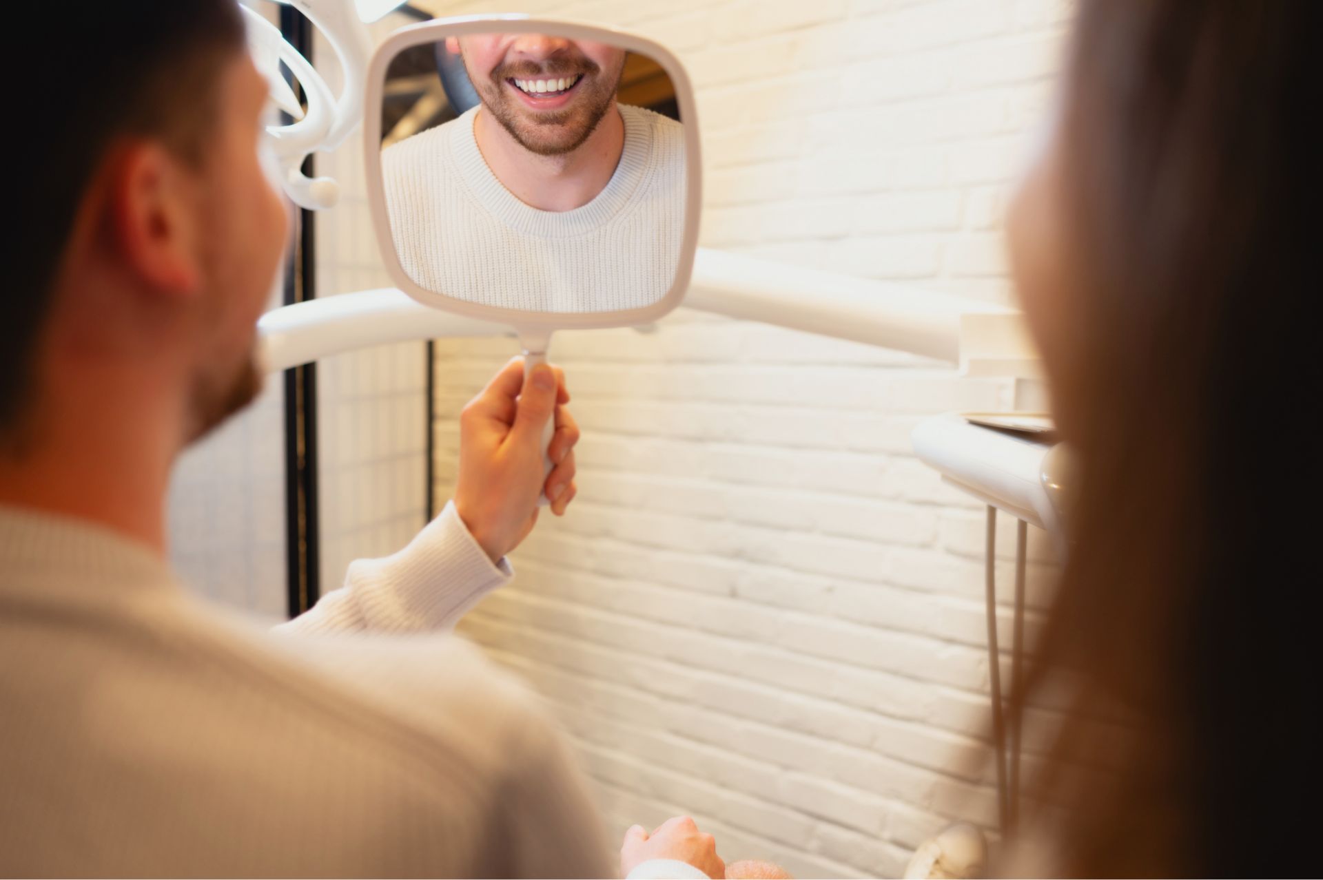 Patient reviewing their smile in a mirror